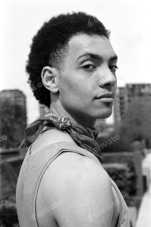 Preview: Young man wearing bandana posing in urban setting, grainy analog portrait