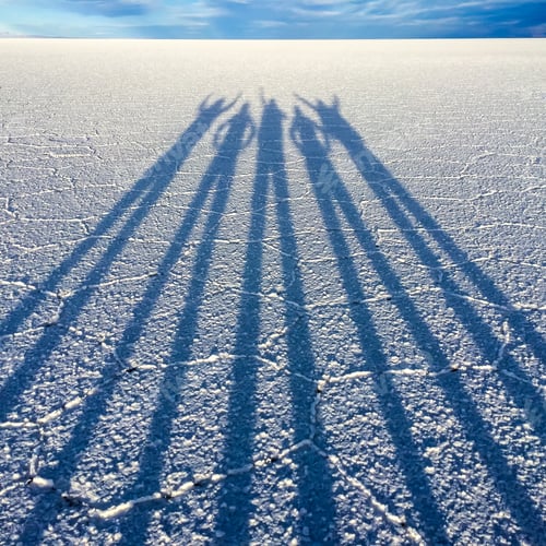 Preview: Long shadows people at dusk sunset in Salar de Uyuni. Salt marsh in southwestern Bolivia