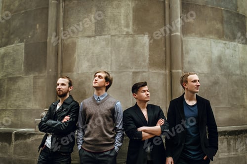 Preview: stylish handsome group of men standing and posing on the background of city street