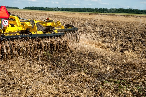 Preview: fragment of a heavy disc harrow in work on a field