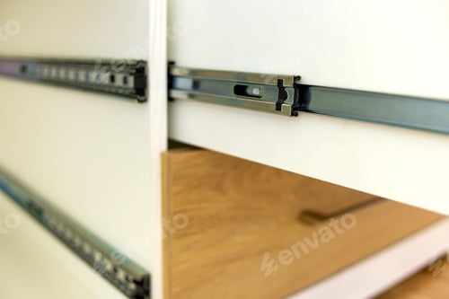 Preview: Close up of installation of wooden drawer in contemporary cupboard cabinet