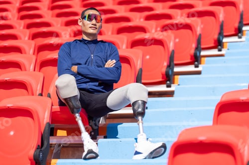 Preview: Asian para-athletes with prosthetic blades sprint on a running track at stadium.