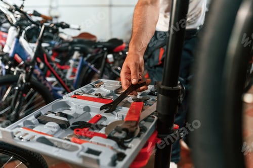 Preview: Taking wrench. Close up view of man's hands that is repairing bicycle
