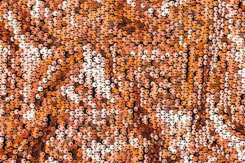 Preview: Textured gold background from round sequins on black fabric with waves. Top view