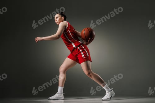 Preview: Female Basketball Player in Action during Training in Red Uniform, Studio Shot for Sports Promotion