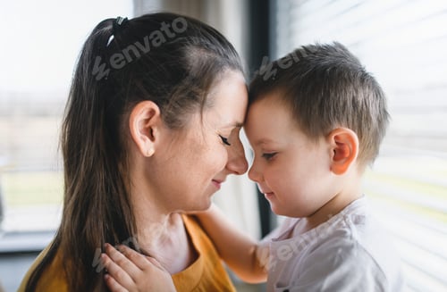 Preview: Mother and child indoors at home, hugging