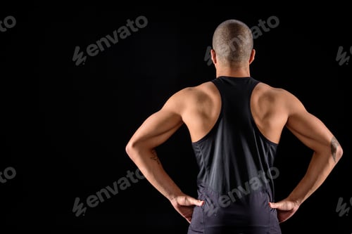 Preview: rear view of muscular african american sportsman standing isolated on black