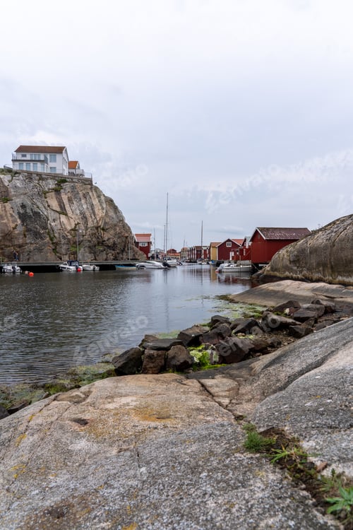 Preview: Image showcases the rocky coastline of a harbor in Munkkyrkan, Smoegen, Sweden