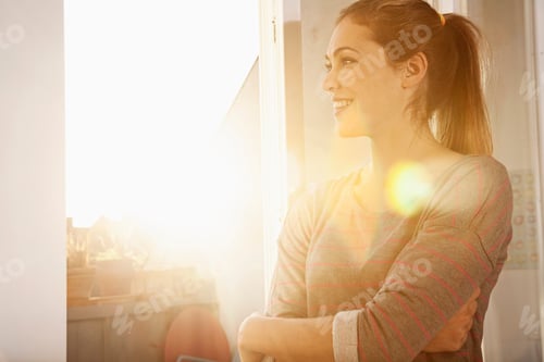 Preview: Portrait of happy woman standing at open window