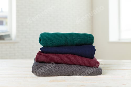 Preview: Stack of white cozy knitted sweaters