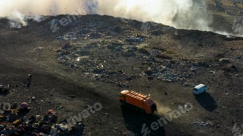 Preview: Aerial view of a garbage truck drives on garbage pile in landfill