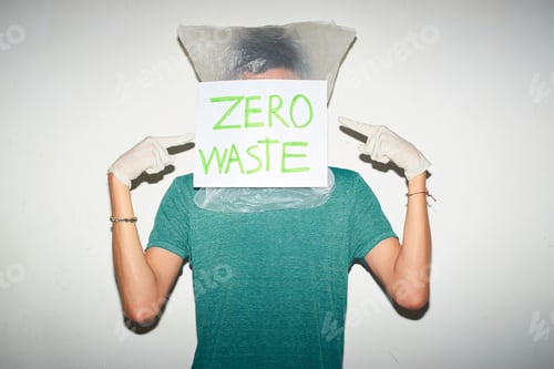 Preview: Young man with plastic bag on his head. Zero waste concept.