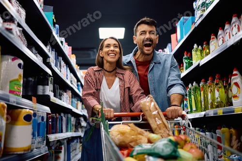 Preview: Carefree couple having fun while shopping in supermarket.
