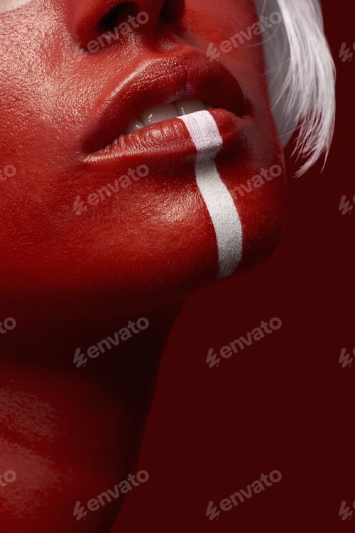 Preview: Vertical shot of a female in red body paint with a white line on a red background