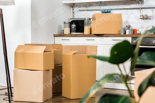 Preview: interior of modern kitchen with cardboard boxes during relocation at new home