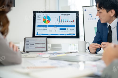 Preview: Businessman or male office worker is looking at the financial report on monitor with his coworkers