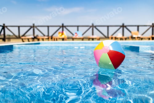 Preview: The ball floats on the water surface in the pool under the summer sun