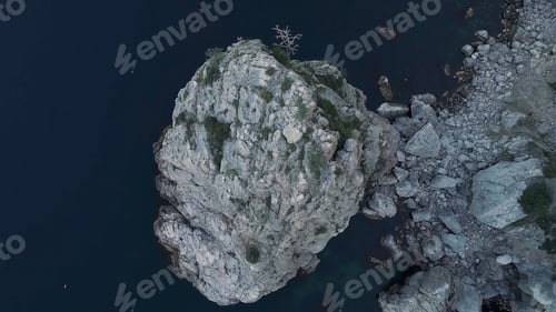 Preview: Magnificent sea with dark blue water and impregnable rocks covered with green trees and bushes. Shot