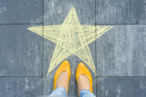 Preview: Drawing of crayons on the asphalt - star and feet of woman