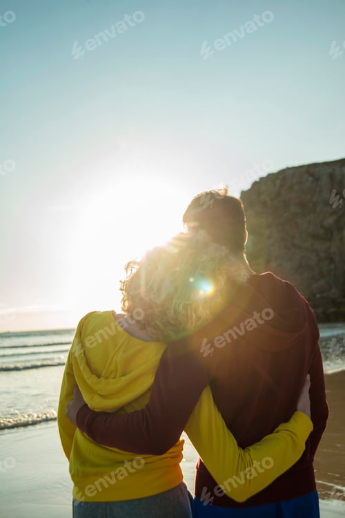 Preview: France, Brittany, Camaret-sur-Mer, teenage couple on the beach looking at sunset