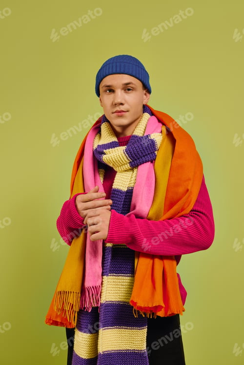 Preview: Fashionable young man exuding style with vibrant attire in a trendy studio setting