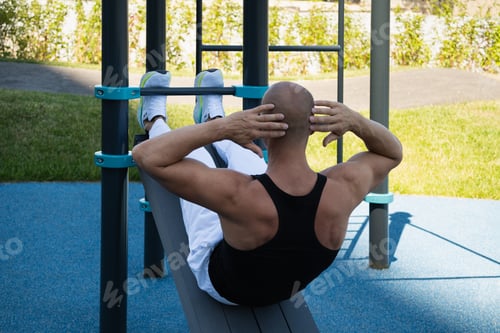 Preview: Athlete make fitness exercises and pumps up abs on street sports ground.