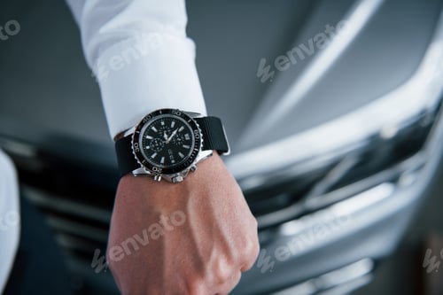 Preview: Close up photo of man's hand in suit with luxury watch near the car