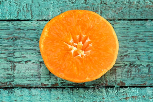 Preview: Close-up view of fresh orange slice on blue wooden table