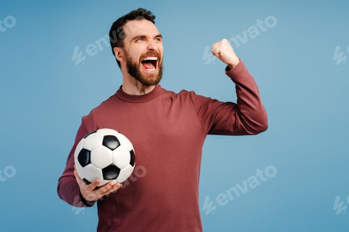 Vista previa: Overjoyed man, football fan holding football ball, rejoicing, supporting favourite team