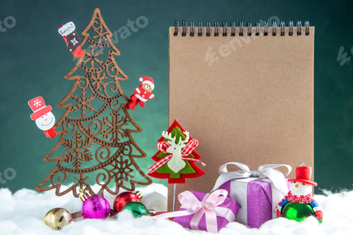 Preview: front view wooden xmas tree with toys pinecone notepad small gifts on green isolated background