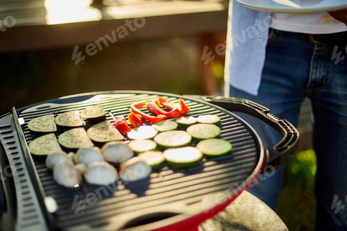 Preview: Close up on man's hand roasting vegetables on the barbecue gas grill