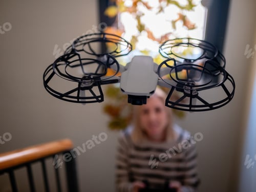 Preview: Soft focus of a drone controlled by a woman, inside a house