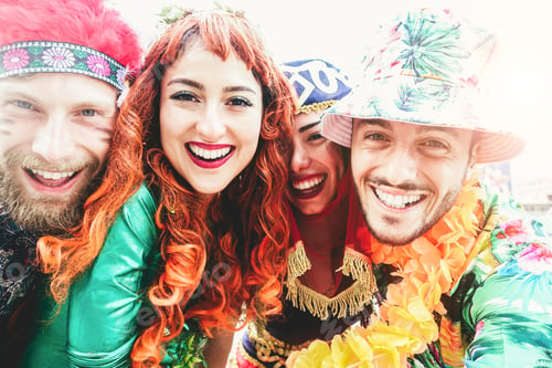 Preview: Happy dressed people celebrating carnival together doing selfie with mobile phone outdoor