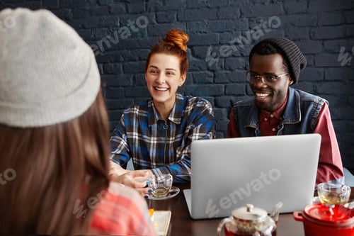 Preview: People, technology and interracial friendship concept. Three happy friends having nice conversation