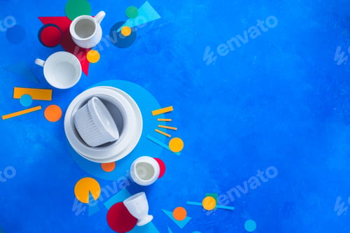 Preview: White dishes and cups on a colorful background with geometric shapes. Color block kitchenware flat