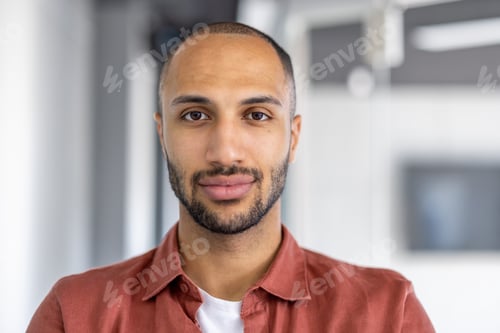 Preview: Close-up portrait of a man looking at the camera, serious and confident. Businessman at workplace