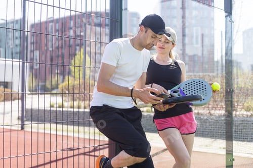 Preview: hands of a woman paddle player is holding balls and the racket at the background at the beginning of