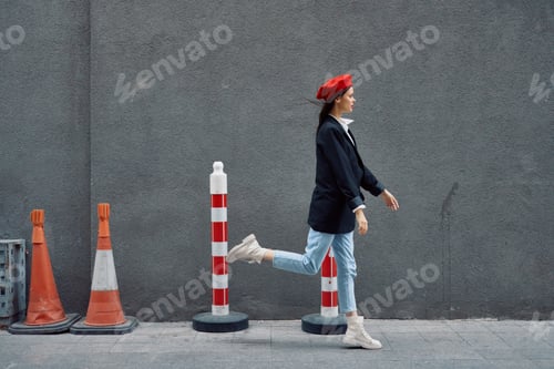 Preview: Fashion woman running down the street in front of the city tourist in stylish clothes with red lips