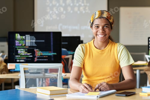 Preview: Black Girl Smiling Sitting at Desk Studying IT at School