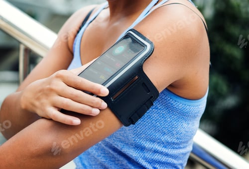 Preview: Healthy woman exercising while using technology