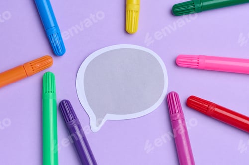 Preview: Paper sticker and multi-colored felt-tip pens on a green background, top view