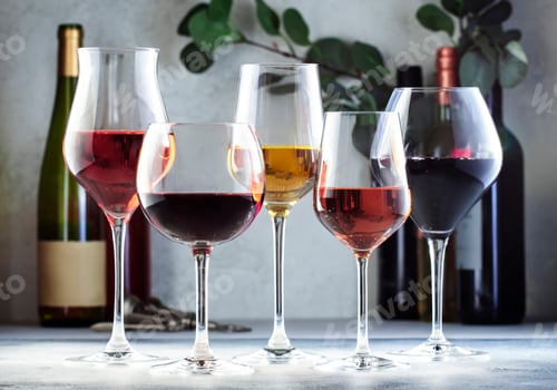 Preview: Wine glasses ans bottles assortment. Red, white, rose wines on gray table