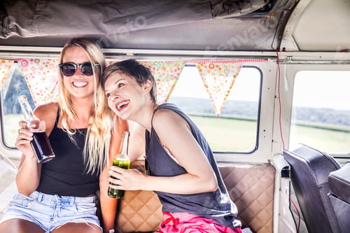 Preview: Two happy women inside van with bottles