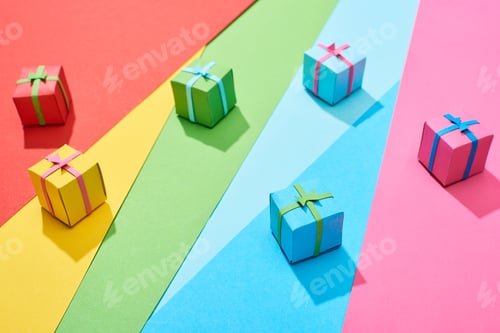 Preview: multicolored gift boxes scattered on rainbow background