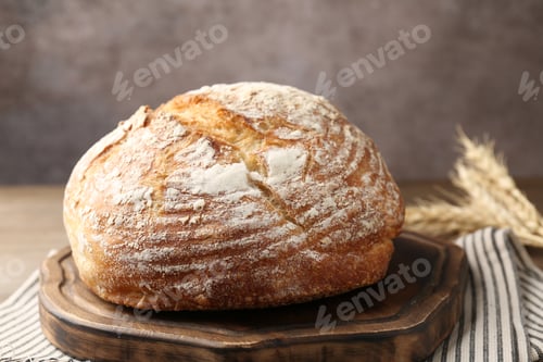 Preview: Loaf of fresh bread and spikes on table, closeup