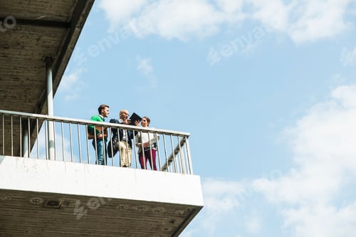 Preview: Three businesspeople discussing on platform under a bridge