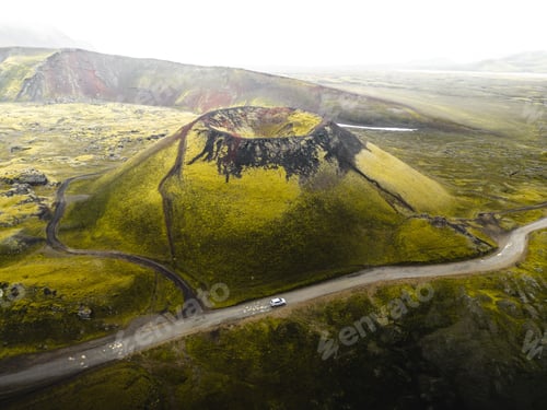 Preview: Aerial view of Laki volcano surrounded by greenery hills with road in Iceland