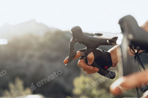 Preview: Hands of a professional cyclist in gloves on handle bar of a bicycle