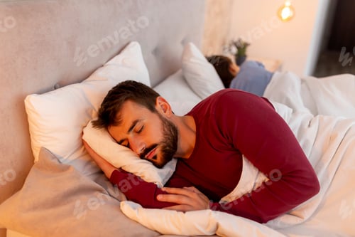 Preview: Couple sleeping back to back in bed
