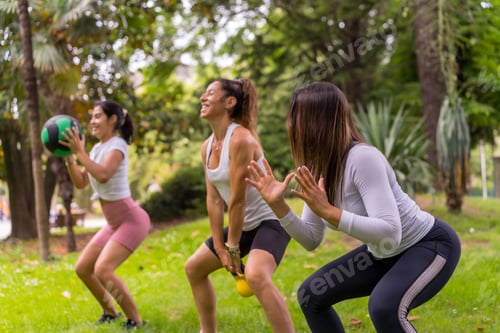 Preview: Group of young girls exercising in a green park